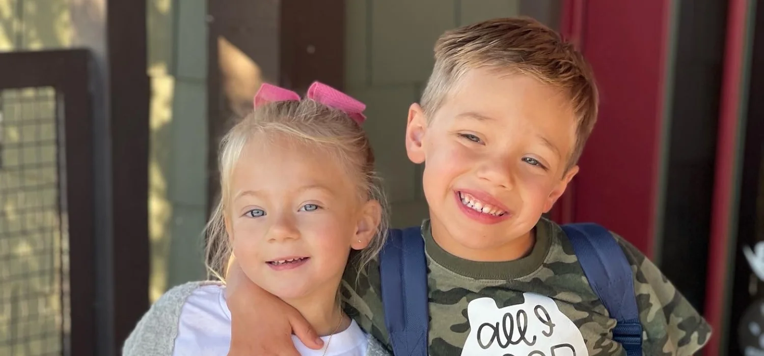 two students wearking backpacks and smiling