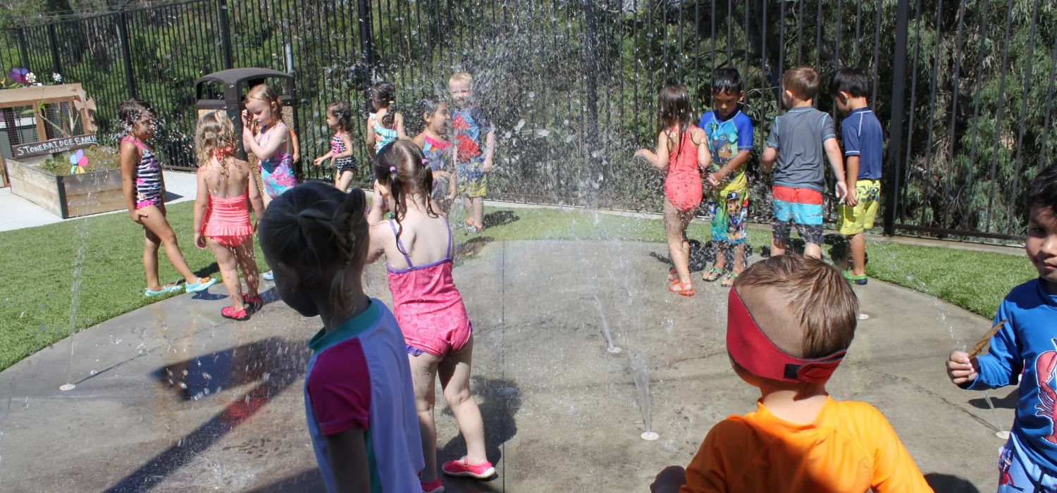 students running through sprinkler